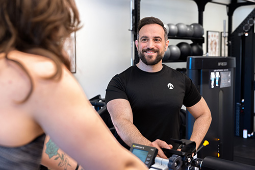 Personlig tränare som ger råd till sin klient på ett gym.